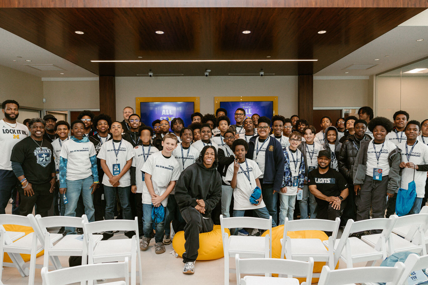 group photo of grand opening attendees with Jahmyr Gibbs of the Detroit Lions