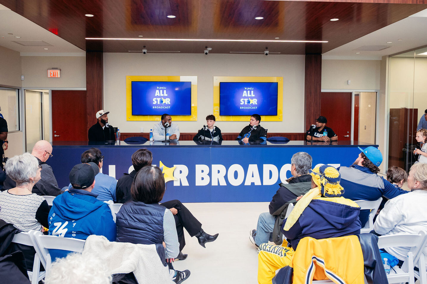People facing a panel of professional athletes.
