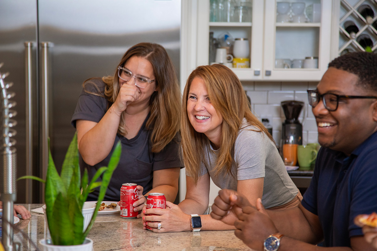 people around the kitchen island laughing