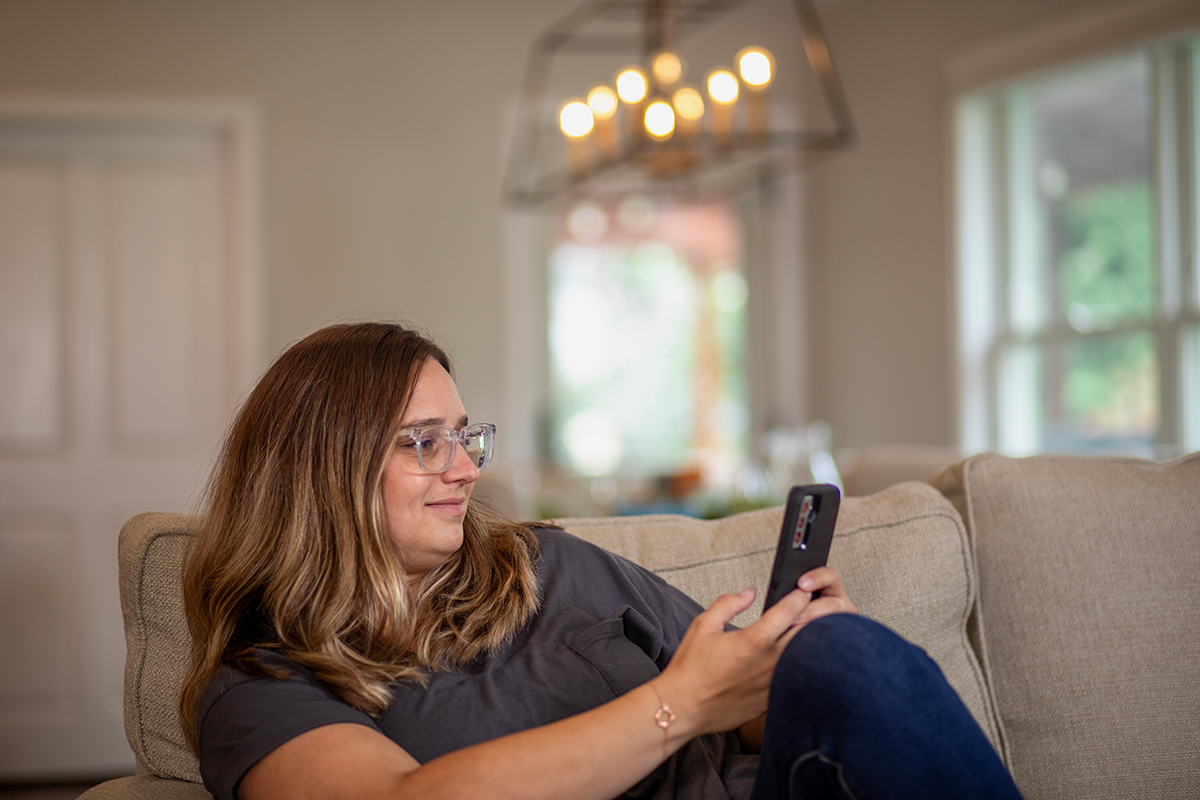 woman with phone sitting on couch
